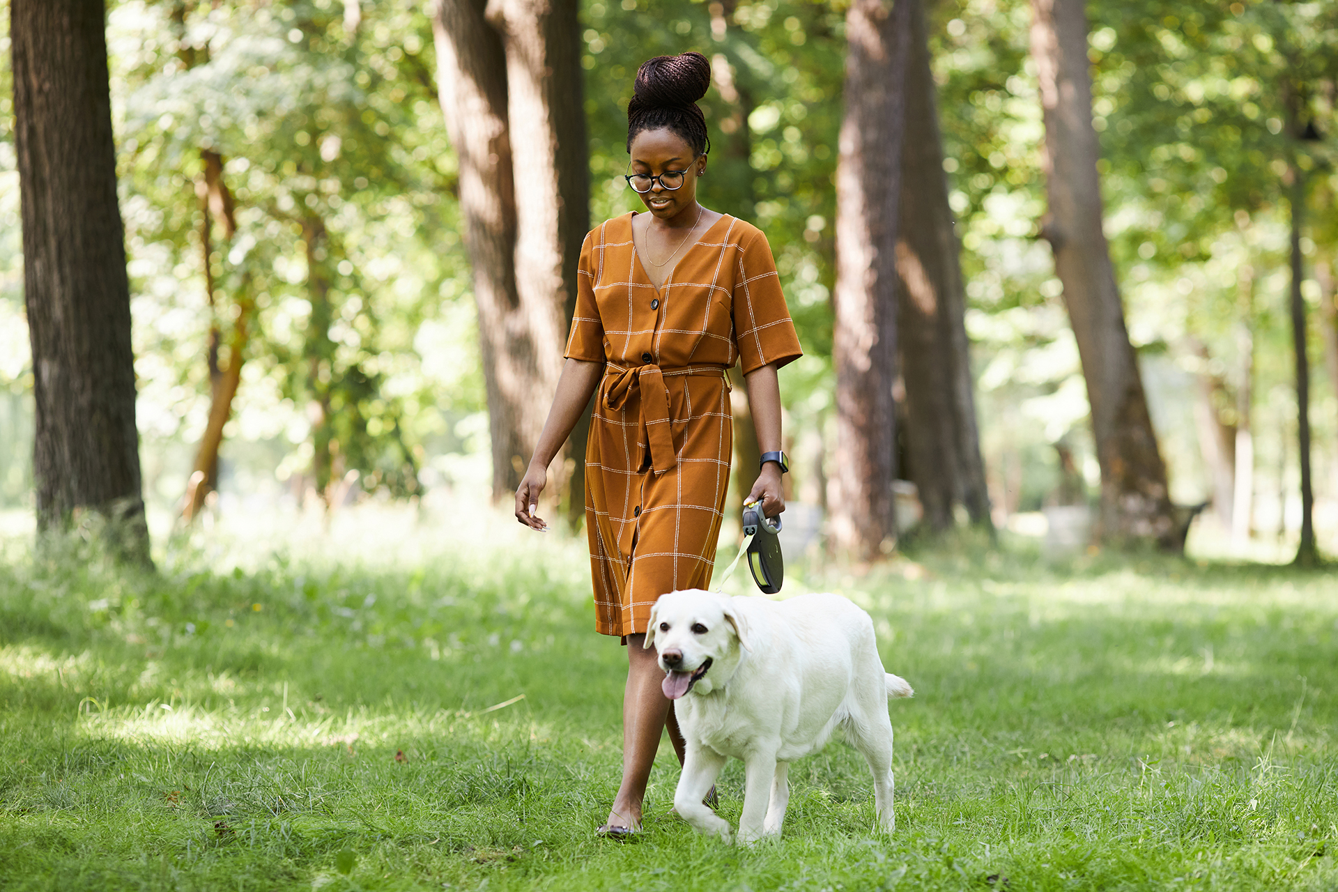 African American woman walking with dog